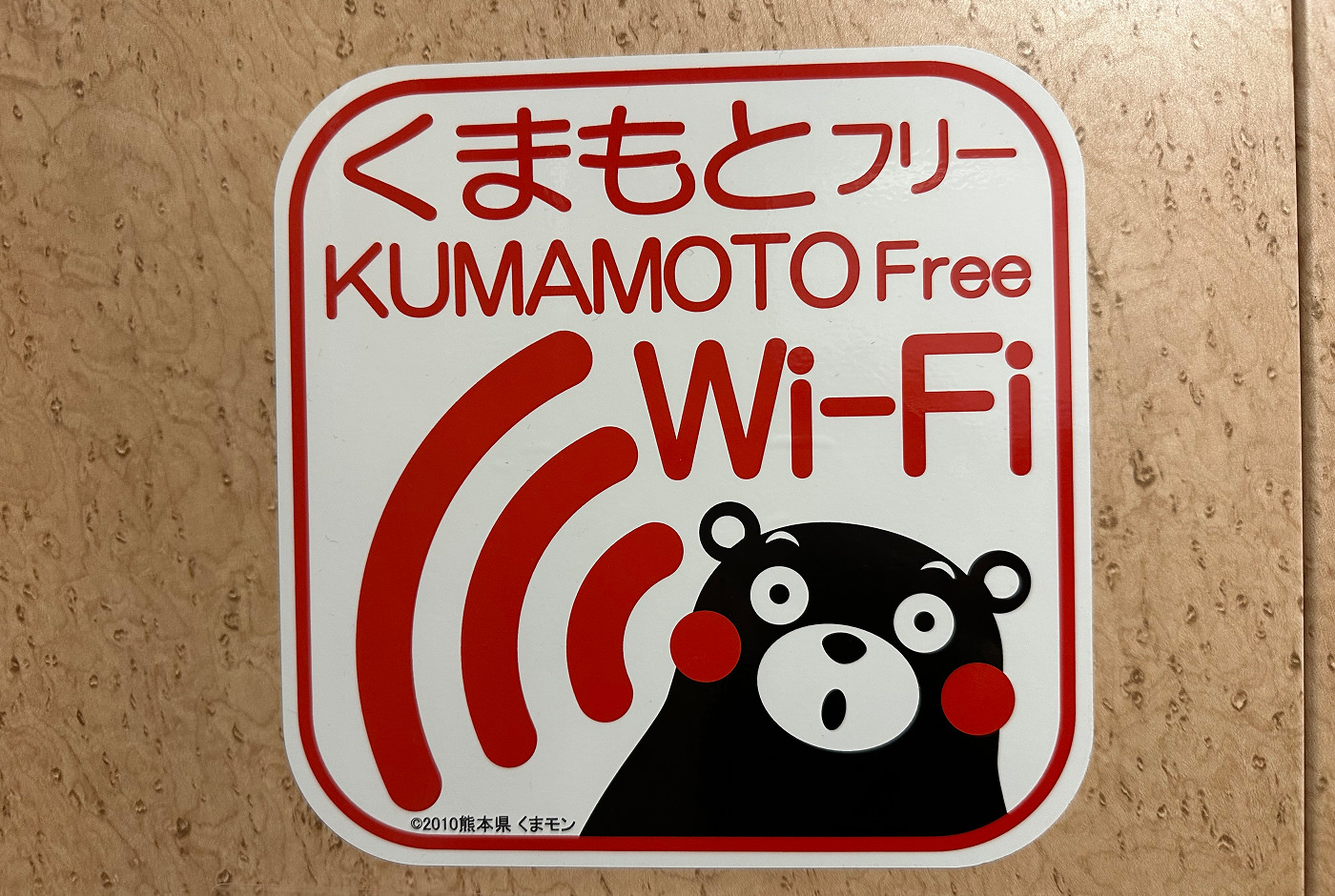 Skylt med texten "Kumamoto Free Wi-Fi" och den svarta glada björnen Kumamon.