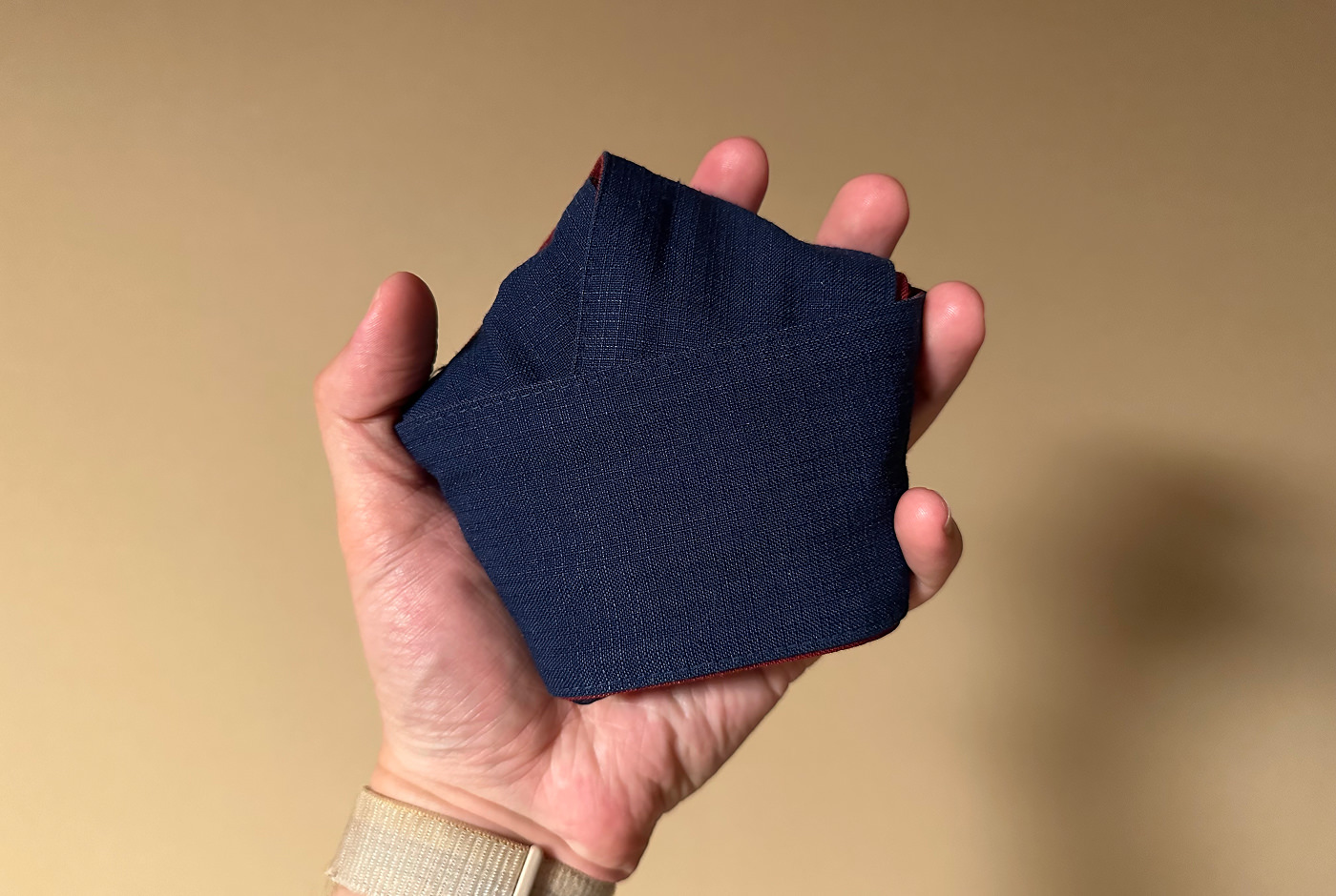 Hand håller i ett blått bälte knutet som en pentagon.