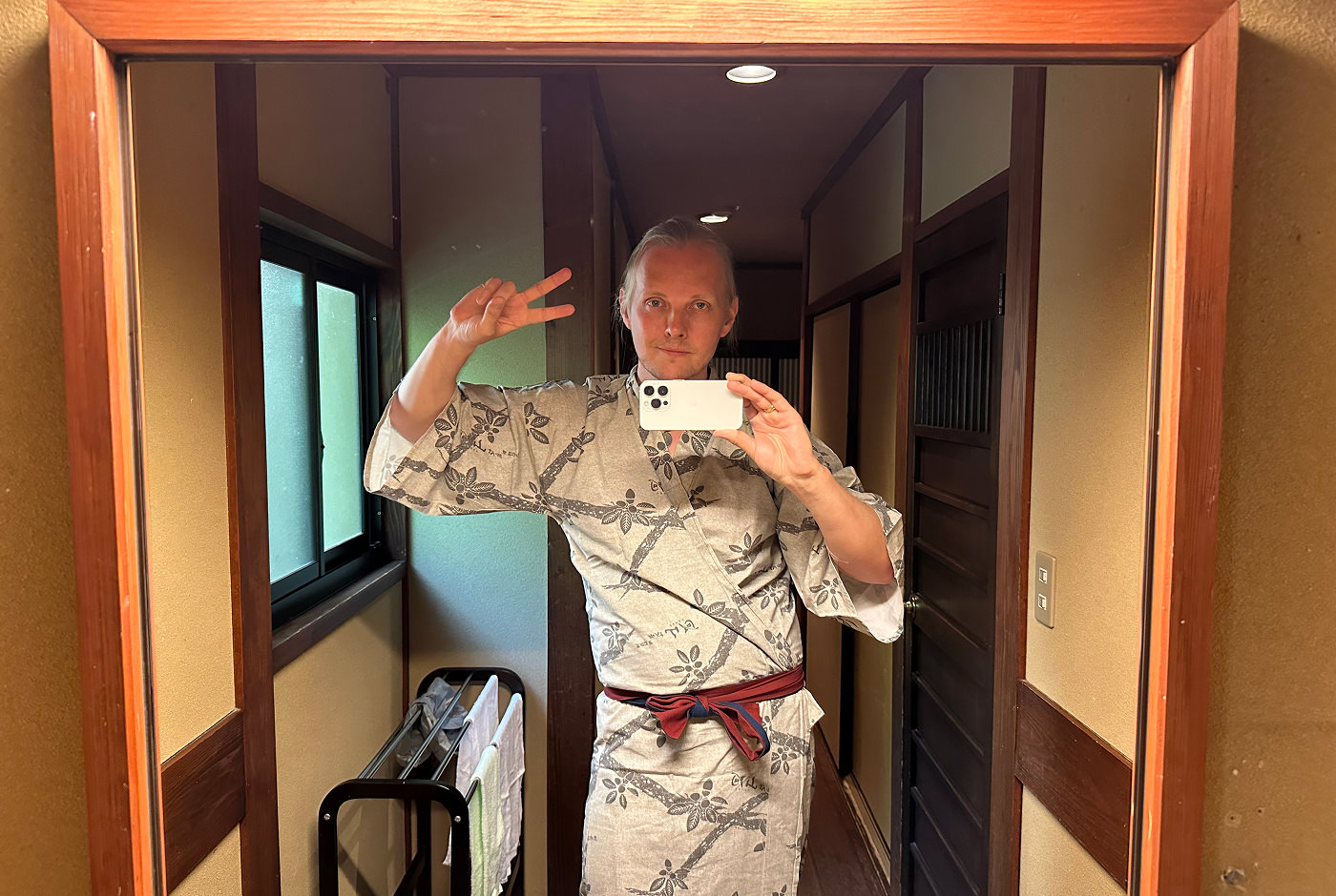 Jag fotograferar mig via en spegel. jag har på en yukata och gör fredstecknet.