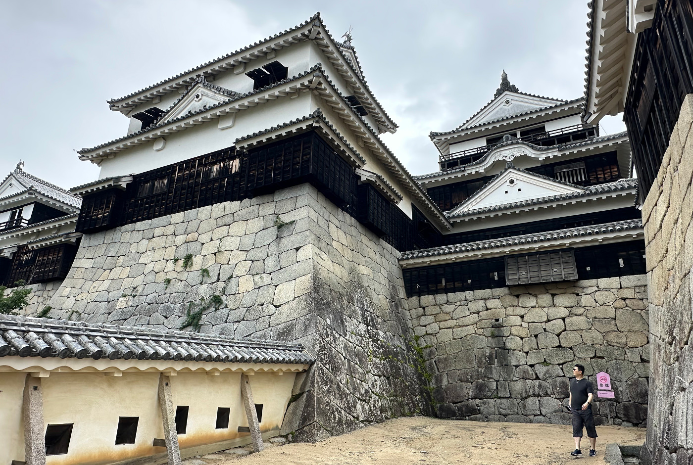 De högsta vita tornen på Matsuyama Castle sett snett nedifrån.