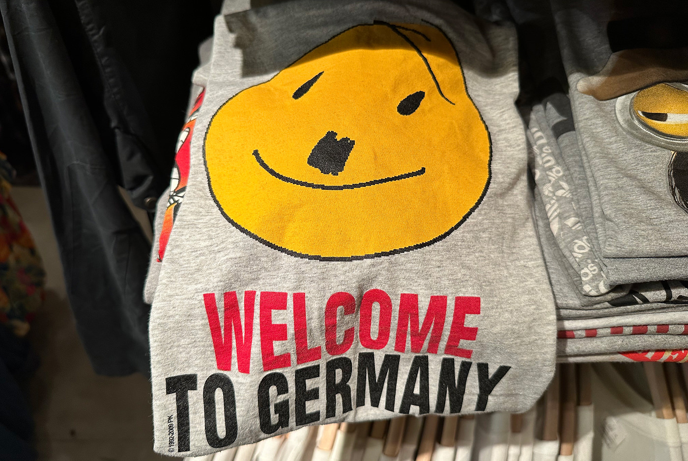 En grå tröja med texten "Welcome to germany" och ett smiley-ansikte som ser ut som Adolf Hitler.