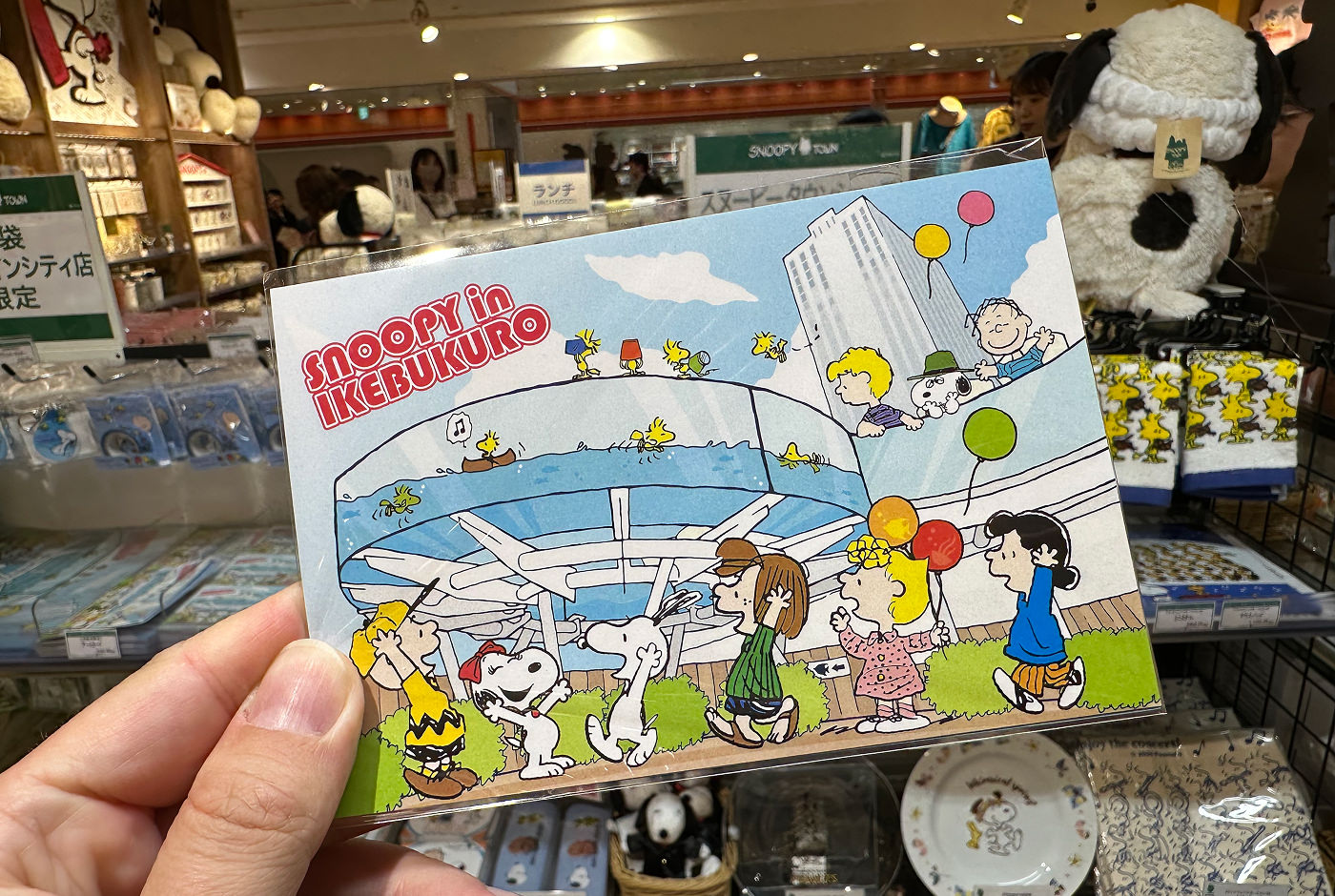 Ett vykort med figurerna från serietidningen Peanuts. En textsnutt på kortet lyder "Snoopy in Ikebukuro".