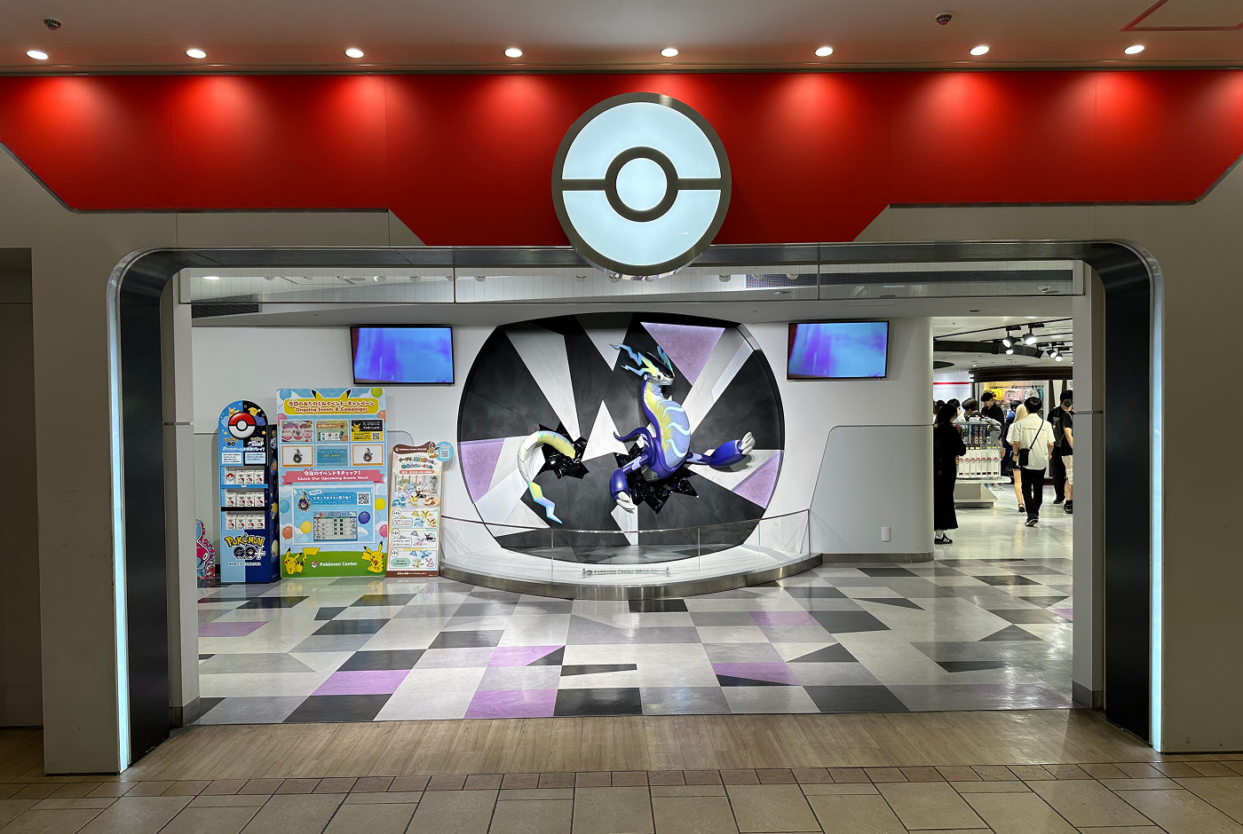 Bred ingång till ett Pokémon Center. Inne är en staty av en pokémon en del av väggen.