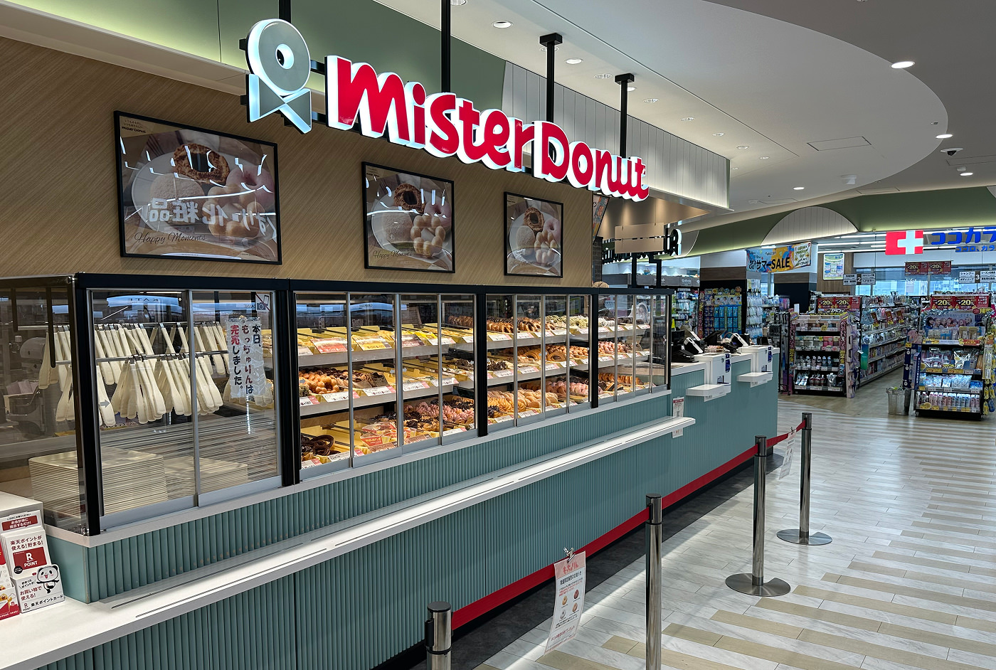Kafé med flera glasskåp fyllda med snyggt garnerade munkar. En skylt ovan lyder "Mister Donut".