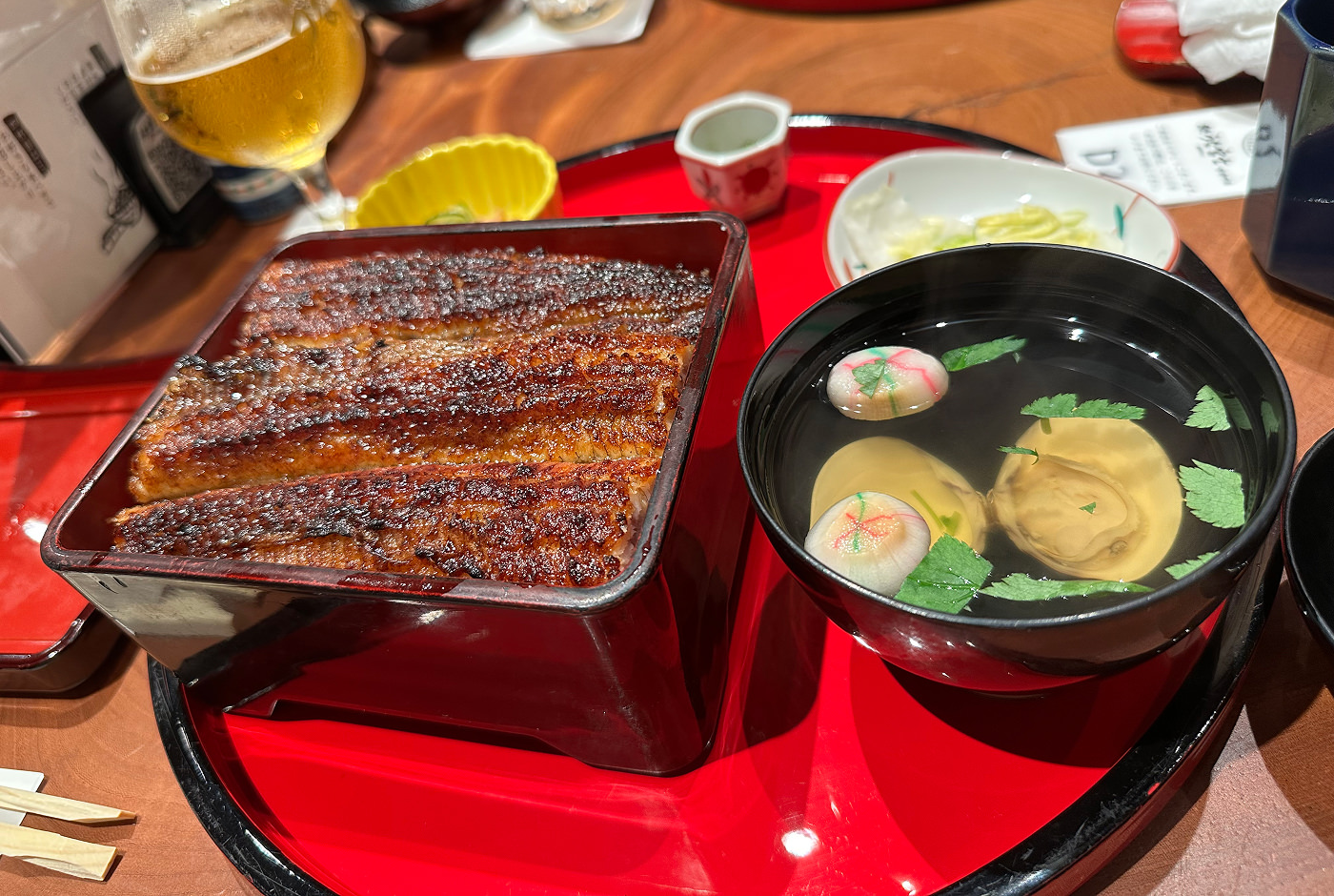 En låda med gyllenbrun kolgrillad sötvattensål och en skål med soppa på mussla.