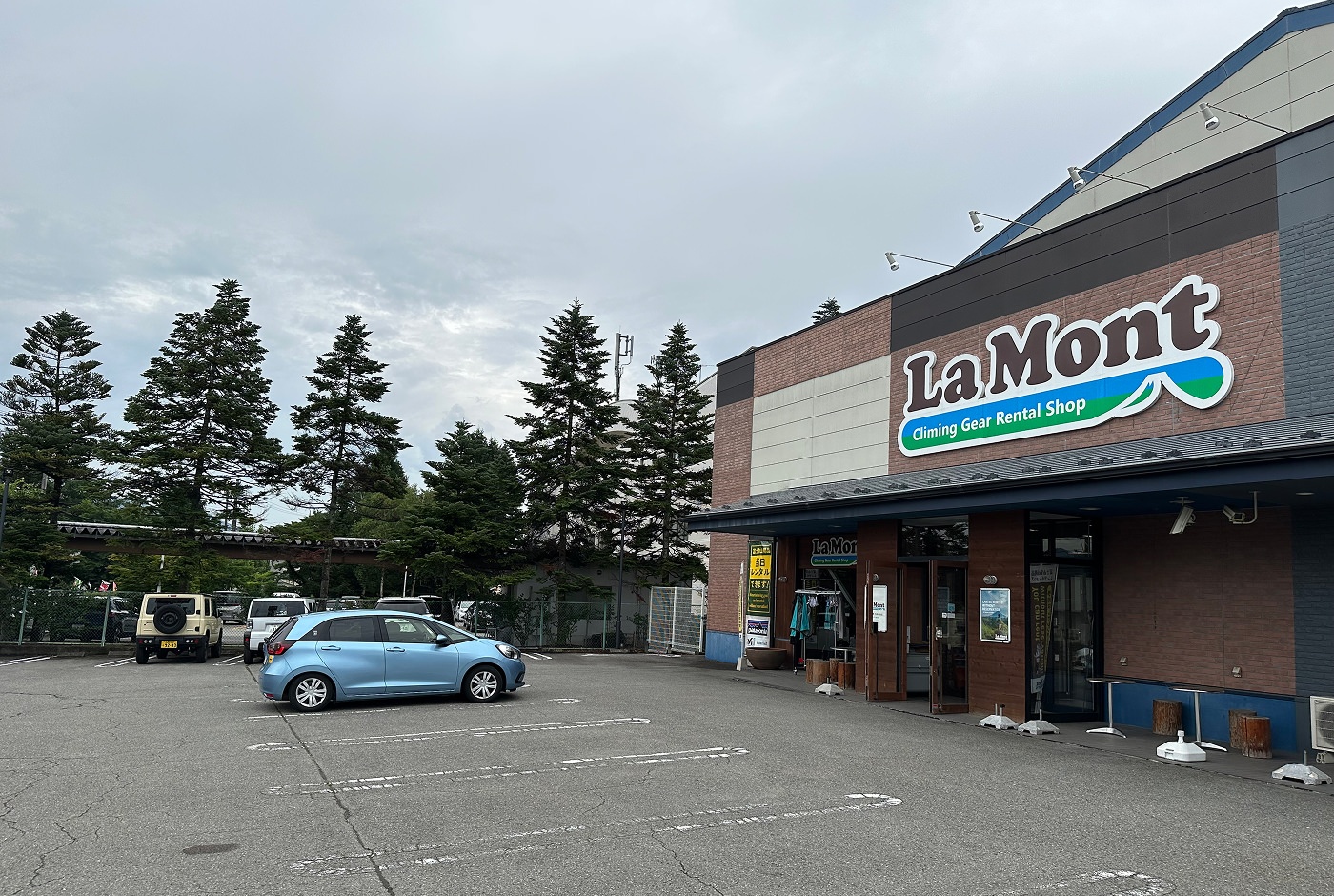 Parkeringsplats utanför en stor butik med en skylt som lyder "La Mont Climbing Gear Rental Shop".