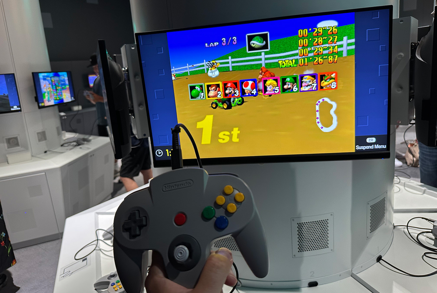 Hand håller i en Nintendo 64-kontroll framför en skärm där Mario kart 64 är ingång. Skärmen visar att jag vunnit ett lopp.