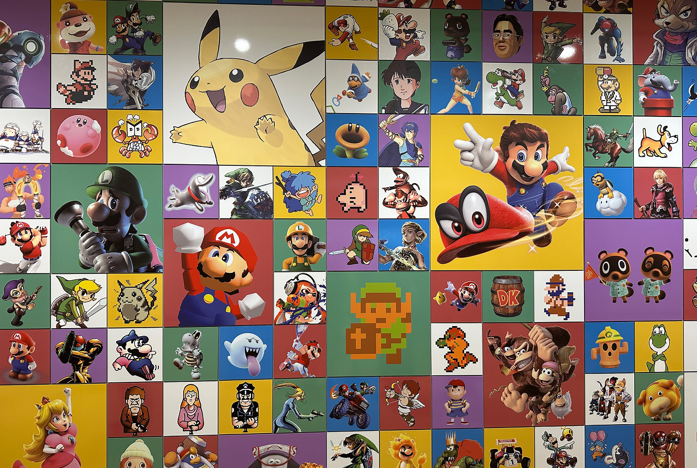 Stor vägg med många små och flera stora porträtt på Nintendos klassiska karaktärer som Mario, Link och Pikachu.