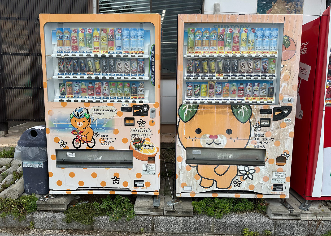 Två ljusoranga dryckesautomater som pryds av en orange tecknad hund med gröna löv som öron.