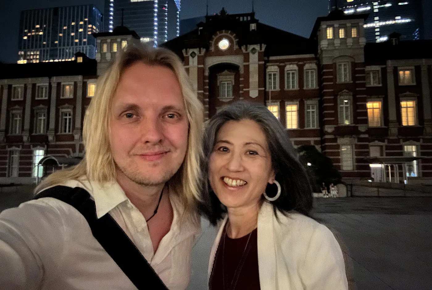 Jag och Keiko star framför Tokyo stations fina tegelfasad. Det är mörkt ute och bilden är grynig.