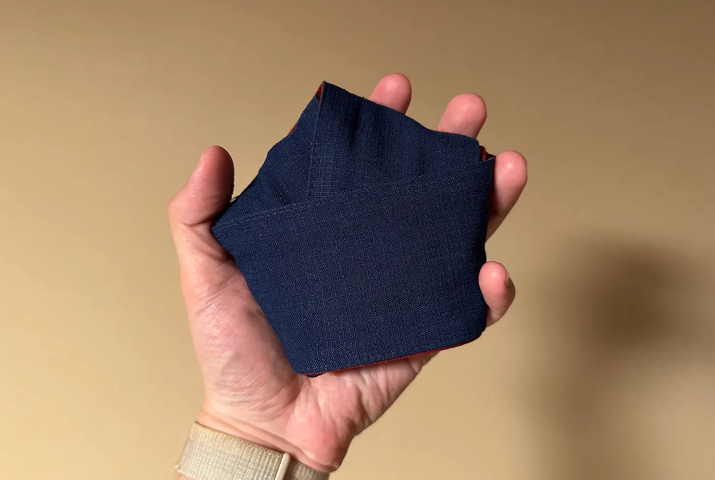 Hand håller i ett blått bälte knutet som en pentagon.