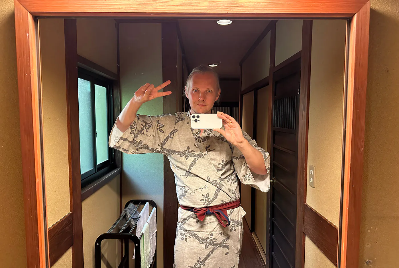 Jag fotograferar mig via en spegel. jag har på en yukata och gör fredstecknet.