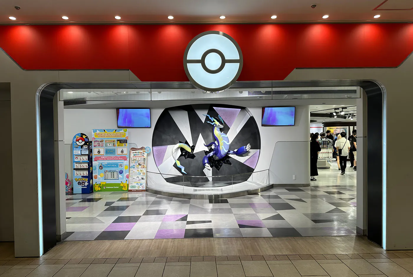 Bred ingång till ett Pokémon Center. Inne är en staty av en pokémon en del av väggen.