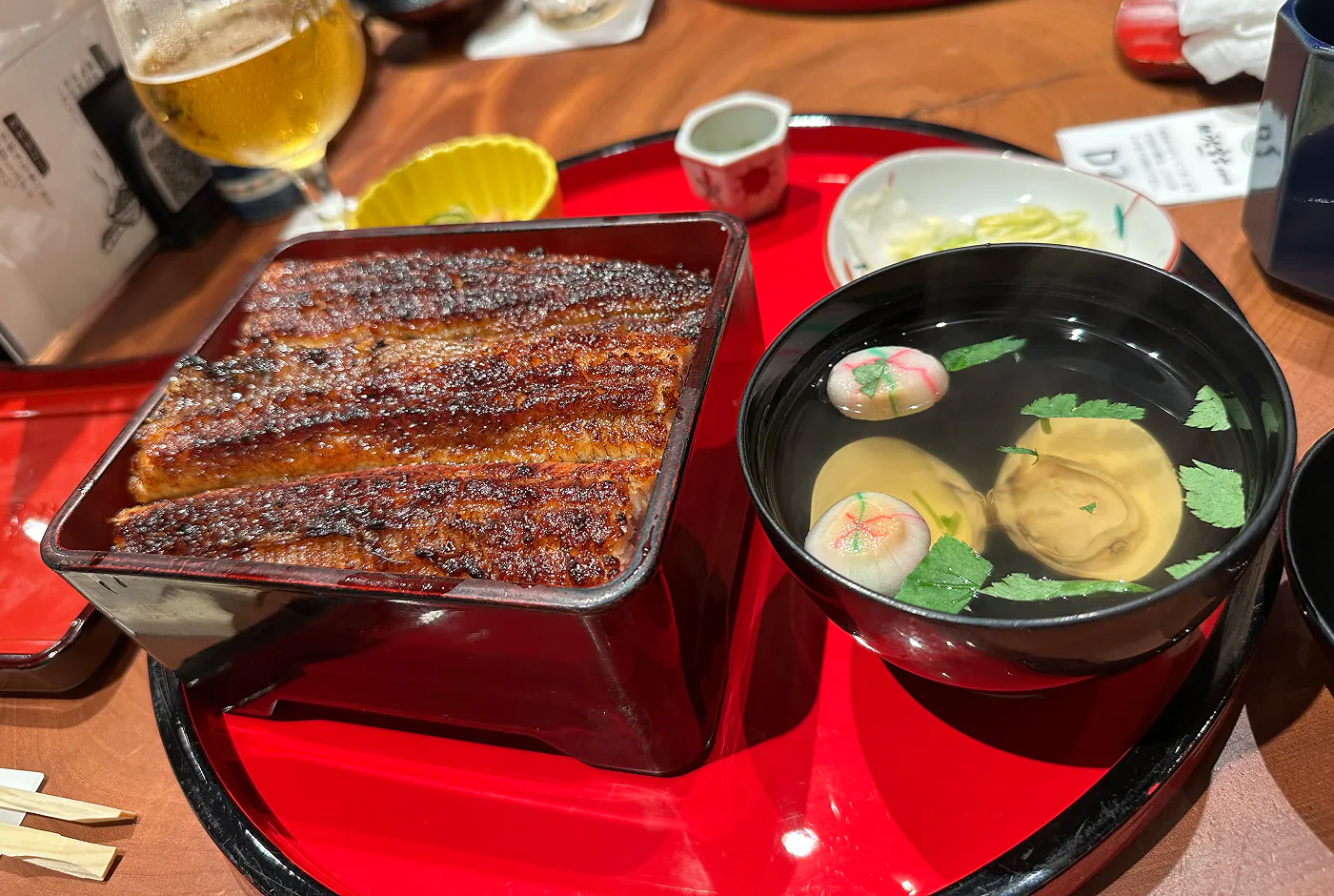 En låda med gyllenbrun kolgrillad sötvattensål och en skål med soppa på mussla.