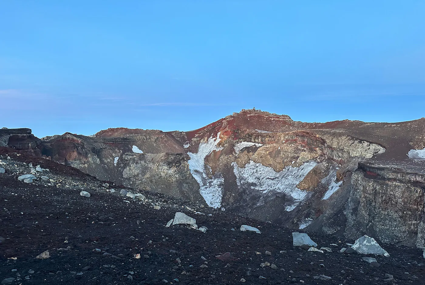 Stor vulkankrater under blå himmel.