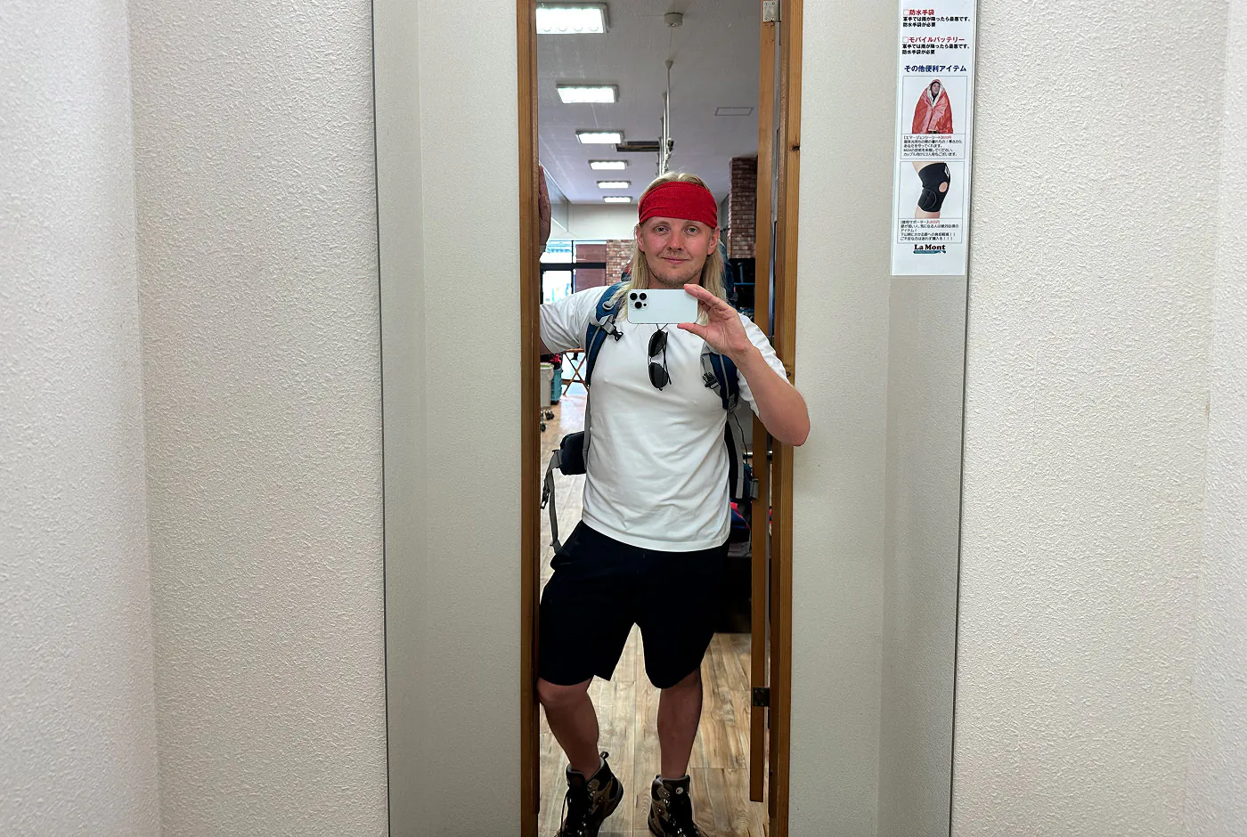 Jag tar en bild framför en spegel. Jag ahr vandringskläder på mig och ler.